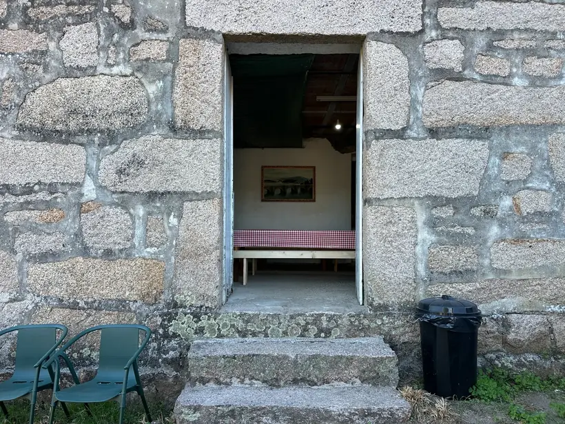 Entrada aberta nunha fachada de pedra con chanzos