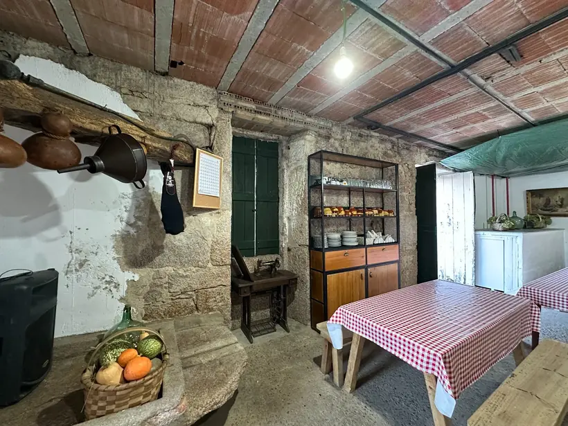 Mesas con manteis de cadros nunha sala de pedra